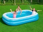 Des enfants s'amusent dans une piscine gonflable dans le jardin.
