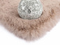 Un tapis en fausse fourrure brun clair et moelleux avec une boule en verre décorative.
