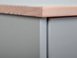Une commode grise avec un plateau en bois.