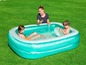 Un adulte et deux enfants jouent dans une piscine gonflable.