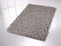Tapis de bain gris avec une texture de petits rouleaux.