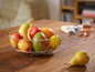 Un panier à fruits en métal avec des pommes, des bananes, de la mangue et du citron