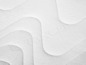 Gros plan sur un matelas blanc avec un motif ondulé.