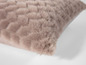 Un coussin moelleux en peluche rose clair.