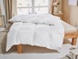 Une couette et un oreiller blancs sur un lit.