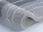 Tapis de bain gris texturé avec revêtement antidérapant.