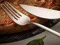 Une fourchette et un couteau à pizza Echtwerk à côté d'une pizza.