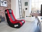 Un fauteuil de jeu rouge et noir avec des haut-parleurs dans une pièce moderne.