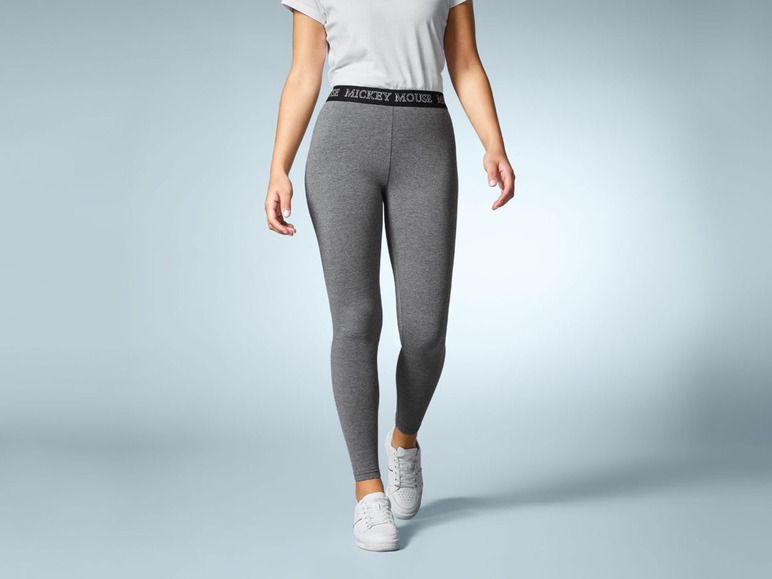 Leggings grises avec le logo Mickey Mouse et baskets blanches.