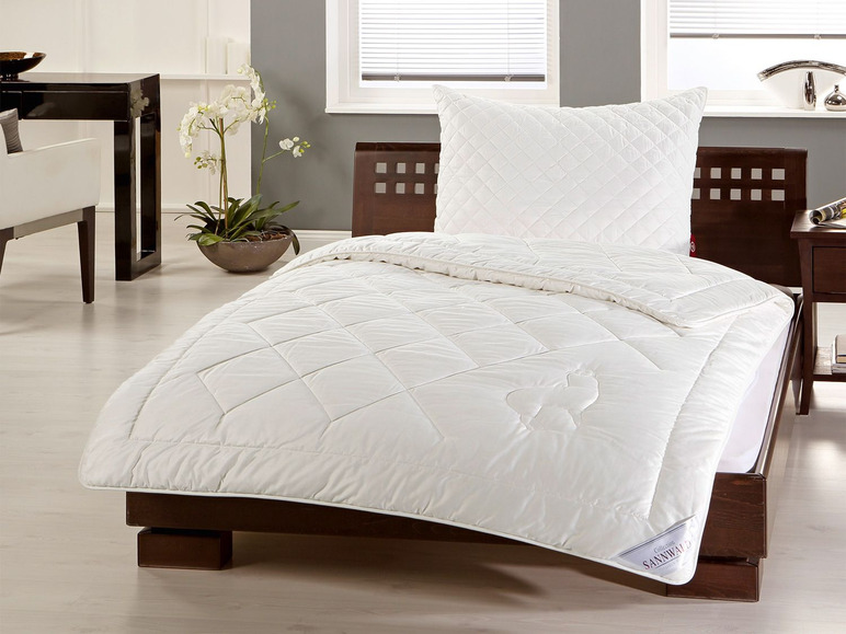 Couette et oreiller blancs de la marque SanNWaldo sur un lit en bois.