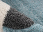 Un tapis avec un motif géométrique en blanc, gris et turquoise.