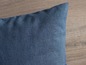 Une housse de coussin bleu foncé en tissu tissé serré.