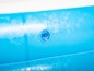 Piscine gonflable bleue avec une valve pour gonfler.