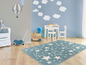 Une chambre d'enfant bleue avec un tapis d'étoiles.