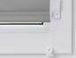 Un store gris avec des clips de fixation blancs sur une fenêtre blanche.