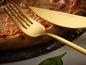 Fourchette et couteau dorés Echtwerk sur une pizza