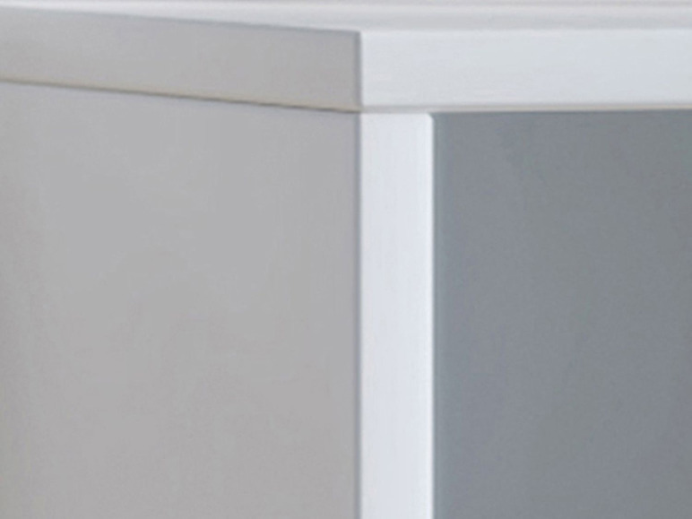 Détail d'une bibliothèque blanche avec des étagères.