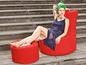 Une femme assise sur un fauteuil beanbag rouge avec un repose-pieds assorti.