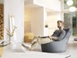 Un homme se détend dans un fauteuil beanbag gris dans un salon moderne.