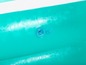 Gros plan sur une piscine gonflable turquoise avec une valve d'air.