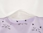 Une culotte lilas avec une bordure blanche et une fermeture éclair, avec un motif de chats.