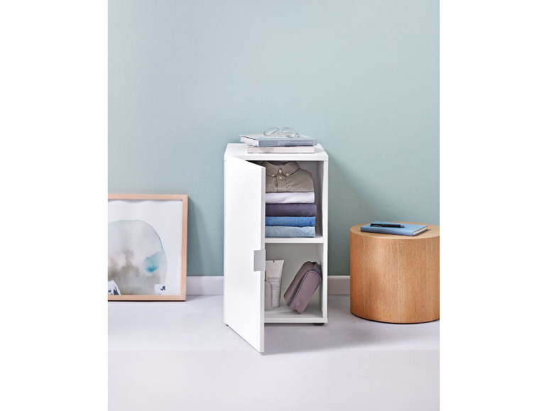 Une armoire de rangement blanche avec deux étagères, remplie de vêtements et d'accessoires.