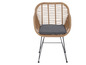 Une chaise en rotin avec un coussin gris.