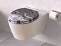 Une toilette avec un couvercle de toilette à motif de gouttes d'eau.