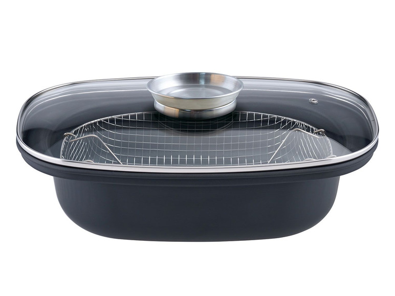 Une casserole noire avec un couvercle en verre, un panier vapeur et un insert supplémentaire.