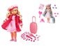 Une poupée avec une robe rose, une valise rose et des accessoires.
