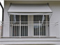 Un auvent gris au-dessus d'un balcon avec une balustrade blanche.