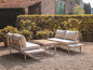 Deux canapés de jardin gris avec une table en bois dans un jardin.