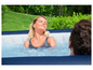 Une femme se détend dans un jacuzzi en plein air.
