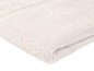 Une serviette de bain beige clair pliée.