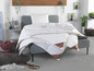 Un lit avec une couette et des oreillers en duvet de la marque 