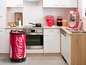 Un réfrigérateur Coca-Cola dans une cuisine avec une machine à popcorn.