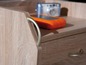 Une table de chevet en bois avec un appareil orange et un appareil photo.