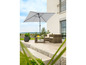 Parasol de jardin avec des chaises et une table en osier sur une terrasse