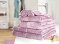 Une pile de serviettes de bain roses dans une salle de bain.