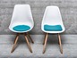 Deux chaises blanches avec des coussins bleus.