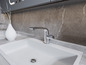 Un lavabo avec un robinet chromé dans une salle de bain moderne.
