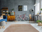 Un téléviseur vintage, un vélo rétro et un tapis brun foncé dans un intérieur moderne.