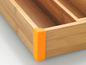 Un range-couverts en bambou avec des coins de protection orange
