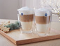 Deux verres de latte macchiato à double paroi Bodum sur un plateau en bois.
