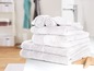 Une pile de serviettes blanches dans une salle de bain.