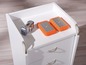 Deux disques durs externes et un appareil photo sur une commode blanche.