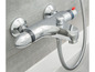 Un robinet de baignoire chromé avec thermostat et pomme de douche flexible.