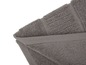 Une serviette de bain et un tapis de bain gris.
