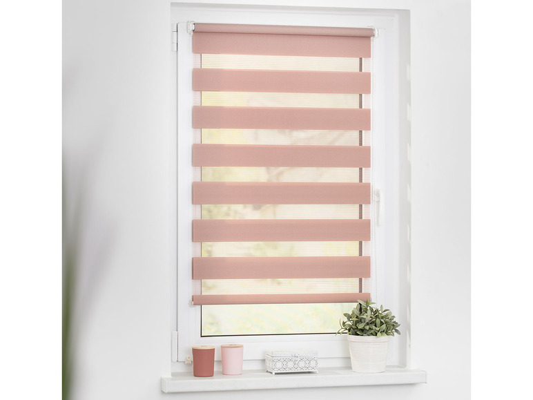 Un store enrouleur jour et nuit rose sur une fenêtre.