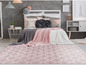 Un tapis rose avec un motif géométrique blanc dans une chambre